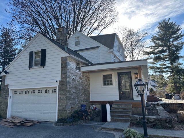 Gladwyne PA exterior renovation with white James Hardie siding, stone details, updated trim and finished curb appeal