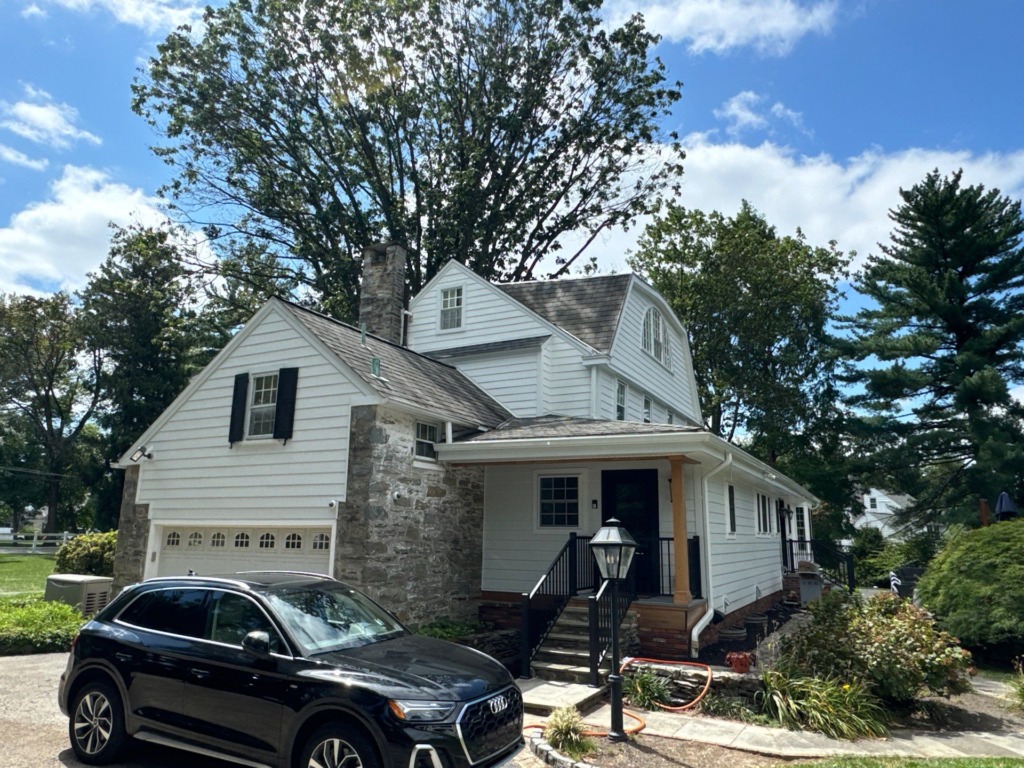 Completed Gladwyne PA exterior renovation with white James Hardie siding, stone accents, updated trim and finished curb appeal