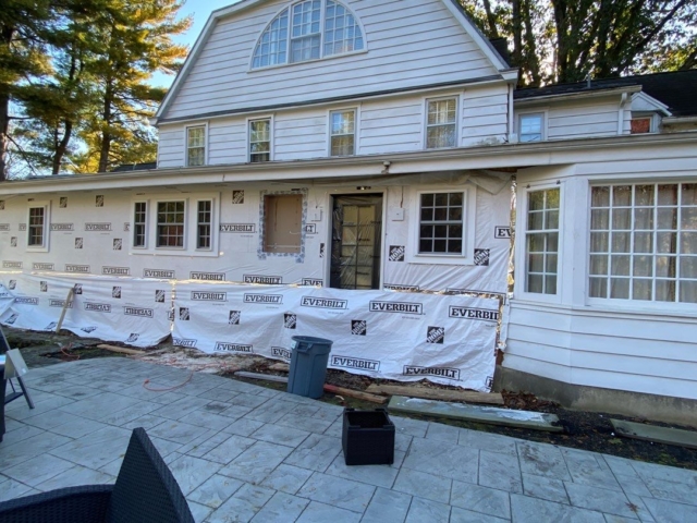 Gladwyne PA home exterior renovation in progress with old siding removed and weather barrier installed before new siding