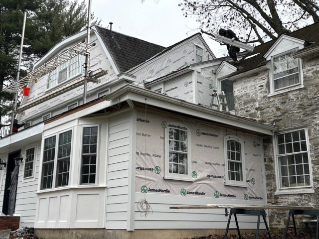 James Hardie siding installation in progress on a Gladwyne PA home with stone exterior and weather barrier