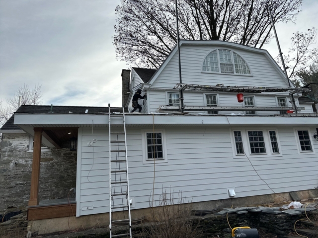 Upper exterior siding work on a Gladwyne PA home with white James Hardie siding and updated roofline trim