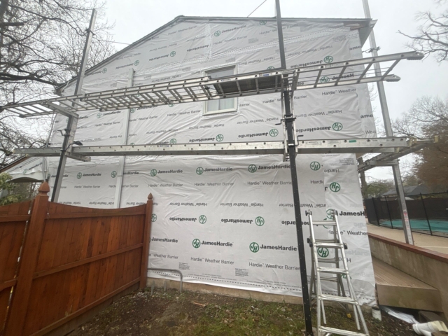 Straight rear gable view showing scaffolding and the completed weather barrier preparation stage. Straight rear gable view showing scaffolding and the completed weather barrier preparation stage.