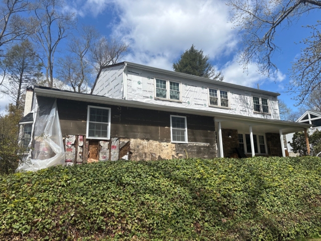 Wide front view of the Yardley, PA home during siding removal and weather barrier installation for its James Hardie exterior transformation. Wide front view of the Yardley, PA home during siding removal and weather barrier installation for its James Hardie exterior transformation.