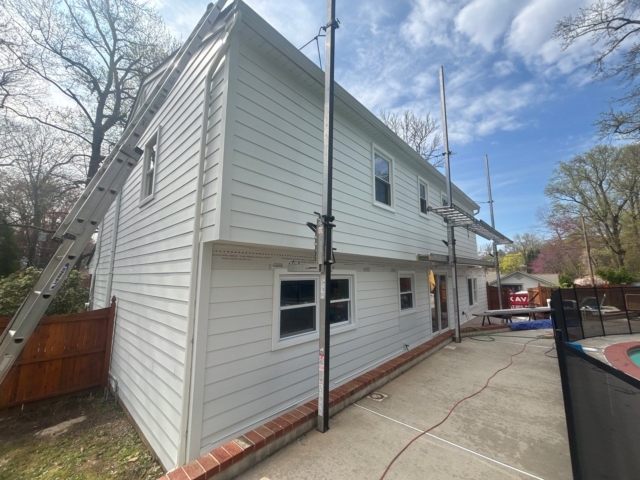 Rear corner of the Yardley home with new white James Hardie siding installed while scaffolding remains in place. Rear corner of the Yardley home with new white James Hardie siding installed while scaffolding remains in place.
