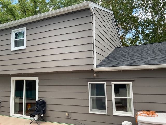 Close rear view of the Yardley home showing siding, white window trim, sliding door, and roofline. Close rear view of the Yardley home showing siding, white window trim, sliding door, and roofline.