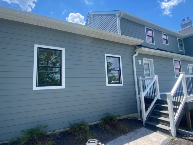 Rear exterior renovated by Porter Family Exteriors with Gray Slate siding, black windows, and white trim