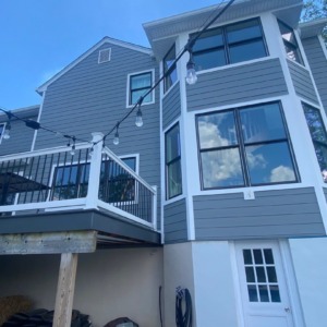 Porter Family Exteriors renovation featuring Gray Slate siding, black windows, white trim, and a raised deck