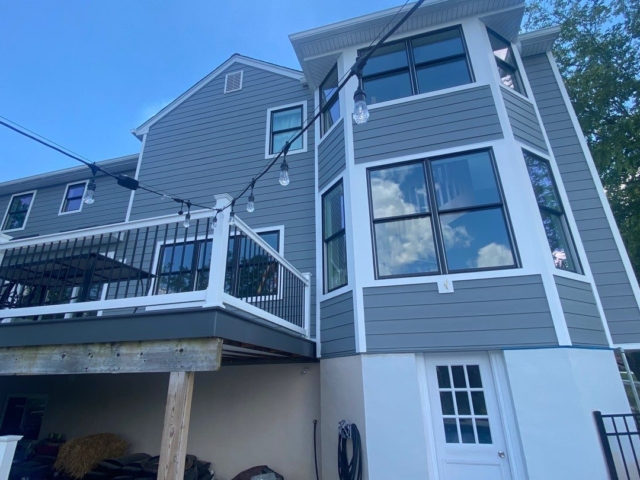 Porter Family Exteriors renovation featuring Gray Slate siding, black windows, white trim, and a raised deck
