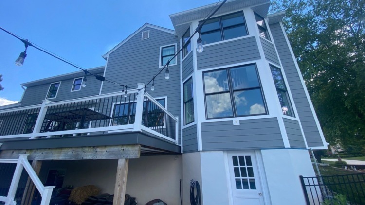 Porter Family Exteriors renovation featuring Gray Slate siding, black windows, white trim, and a raised deck