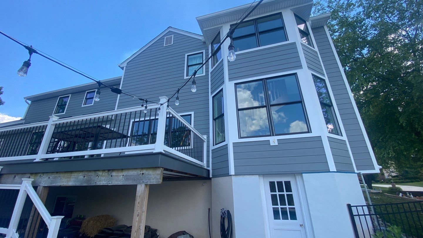 Porter Family Exteriors renovation featuring Gray Slate siding, black windows, white trim, and a raised deck