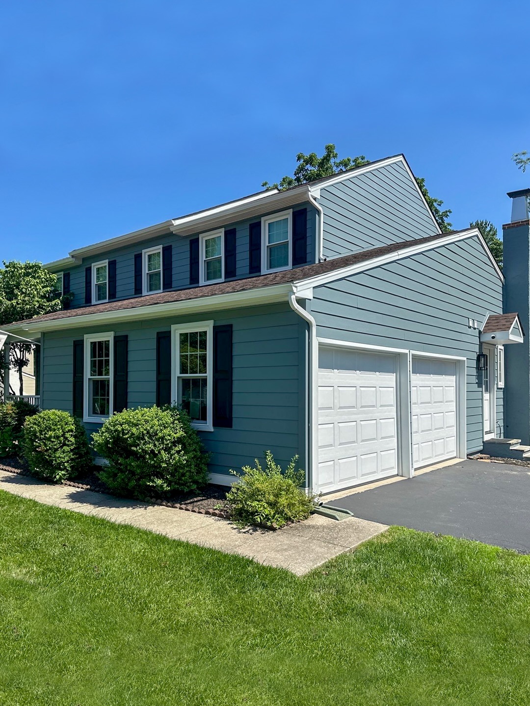 Two-story home with blue-gray siding and a well-maintained asphalt shingle roof