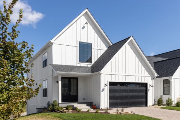 Modern farmhouse-style home with white siding and a dark architectural shingle roof