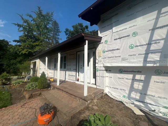 Front entry wrapped with James Hardie weather barrier before new siding installation