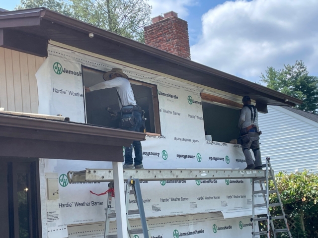 Porter Exterior Crew working on upper window openings with James Hardie weather barrier installed